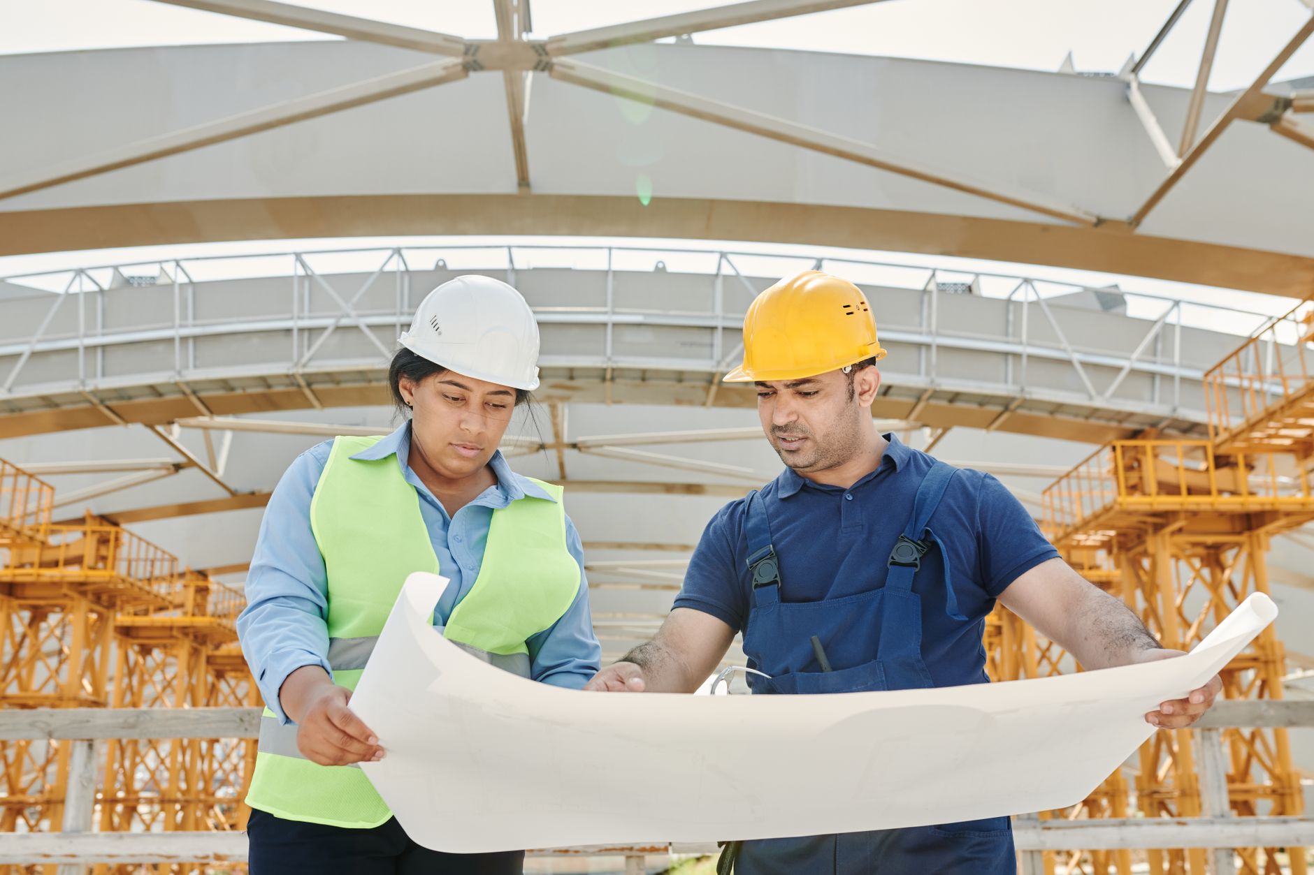 A team of professionals holding electrical monitoring blueprints